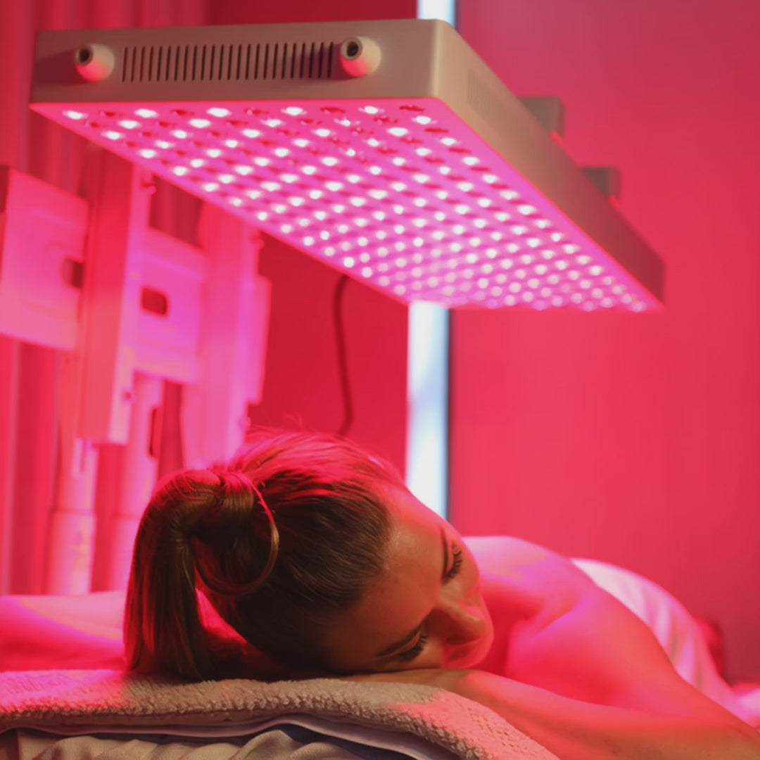 une femme sous un appareil de photobiomodulation pbm lumière rouge et proche infrarouge